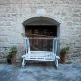 Tra tavoli e oggetti lasciati un po� alla rinfusa, notiamo l�ingresso in legno della masseria...